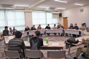 参加者たちが円になって座り登壇者の話を聞いている様子