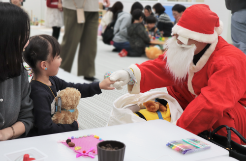 サンタクロースが女の子と握手をしている様子