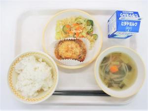 お皿に焼きメンチカツ、付け合わせにサラダ、ごはん、スープ、牛乳がトレイにのっている