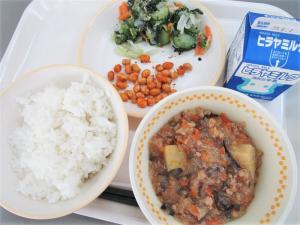 トレーに乗ったご飯、おかず、牛乳の画像