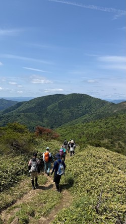 青空と連なる山々の間を行く様子