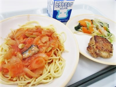 トレーの上にパスタが盛り付けられたお皿、副菜、牛乳の写真