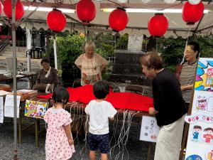 祭りの参加する子供2人を迎え入れる4人の女性たち