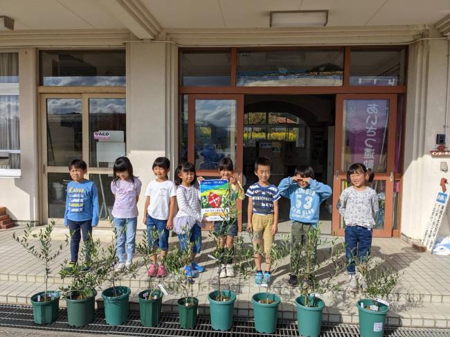 2022年11月2日日置オリーブを育てる会から日置小学校1年生8名へのオリーブ苗木贈呈式の記念写真